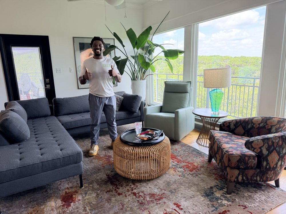 A Nu2U Moving crew member giving a thumbs up inside a client's living room after a move